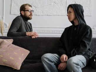 A psychologist and teenager engage in a counseling session in a cozy office setting.