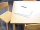 From above of application form on paper sheets near pen on wooden desk in daylight